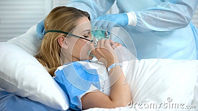 Nurse wearing female patient oxygen mask, preparation before surgery, hospital Stock Photo