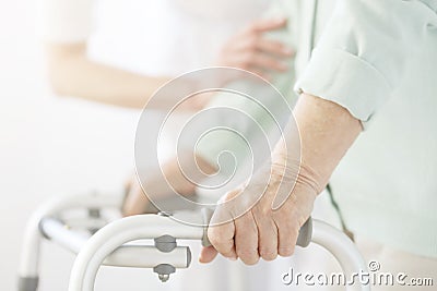 Nurse supporting elderly person Stock Photo