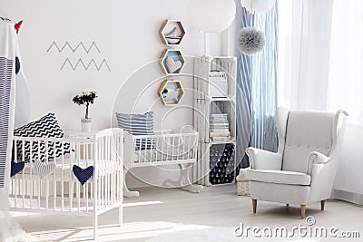 Nursery with white chair and cradle Stock Photo