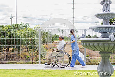 Nursing Home Care concept. asian Young nurse disabled elderly man. Nurse, care home and elderly man with disability in a Stock Photo