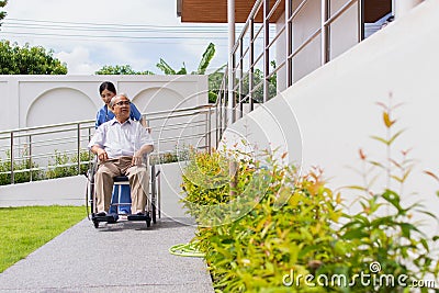 Nursing Home Care concept. asian Young nurse disabled elderly man. Nurse, care home and elderly man with disability in a Stock Photo