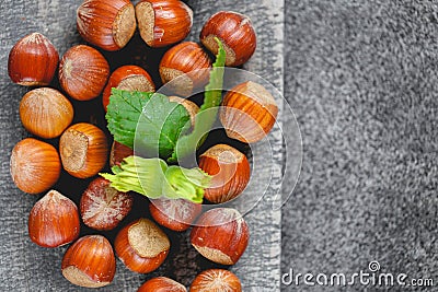 Nut abundance. Hazelnuts on a gray wooden board on a gray slate background. Fresh harvest of hazelnuts. Stock Photo