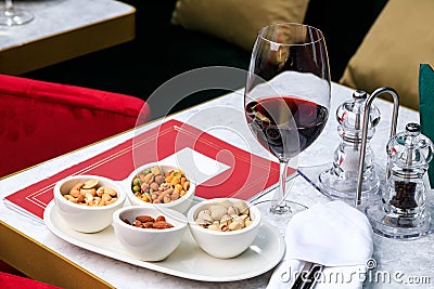 Nut set. Greek mix of nuts. pistachios, almonds, cashews. Glass of red wine. Place for text Stock Photo
