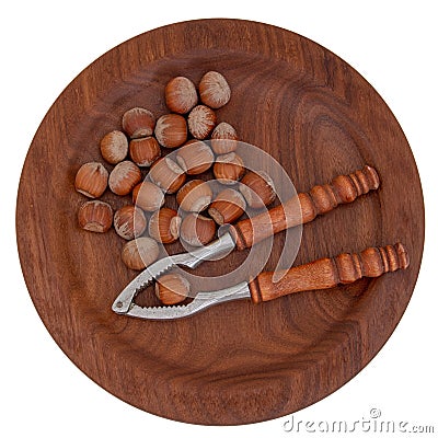 Nutcrackers and hazelnuts on beautiful wooden plate, isolated on white. Typical Christmas, seasonal treat. Stock Photo