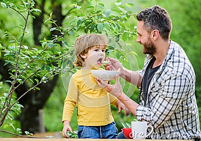 Nutrition habits. Little boy and dad eating. Nutrition for kids and adults. Healthy nutrition concept. Feeding baby Stock Photo