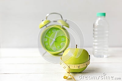 Nutrition start up workout plan. Close up green apple with measuring tape. Stock Photo