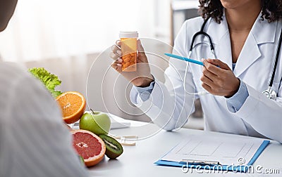 Nutritionist showing slimming pills to female patient Stock Photo