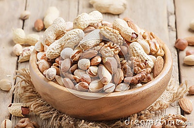 Nuts set assortment in bowl with almonds, pistachios, cashews, hazelnuts, peanuts, Brazil nuts, walnuts, vintage wooden kitchen Stock Photo