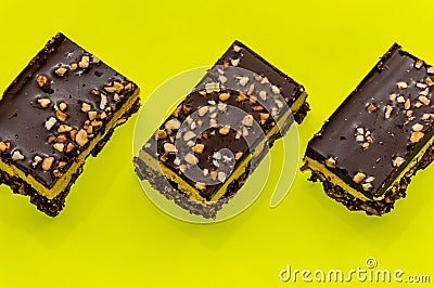 Three nutty brownie bars on a yellow background Stock Photo