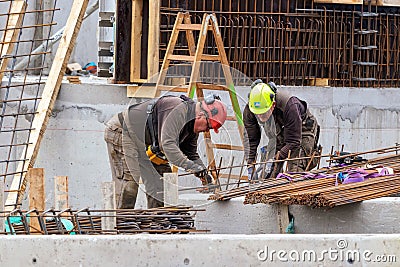 Construction workers bending - wiring concrete steel bars outdoors in Nuuk. Editorial Stock Photo