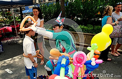 NYC:Clown Making Balloon Hats at Street Fair Editorial Stock Photo