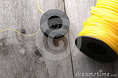 Nylon grass trimmer line and trimmer head on an old wooden background with copy space Stock Photo