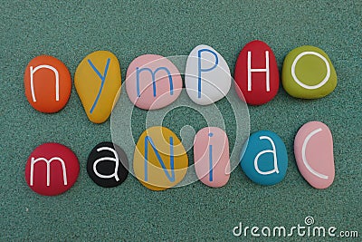Nymphomania word composed with multi colored stones over green sand Stock Photo