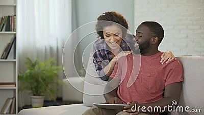 O homem feliz que consulta com a esposa sobre a compra do carro novo, mostrando oferece na tabuleta vídeos de arquivo O homem feliz que consulta com a esposa sobre a compra do carro novo, mostrando oferece na tabuleta vídeos de arquivo