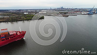 O navio de recipiente carregado grande vermelho do frete da carga chega no porto industrial urbano em tiro aéreo surpreendente do filme O navio de recipiente carregado grande vermelho do frete da carga chega no porto industrial urbano em tiro aéreo surpreendente do filme
