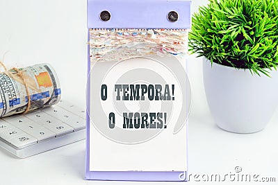 o tempora, o mores (O, the times O, the morals) Latin phrase on a piece of a desktop calendar with tear-off pages Stock Photo