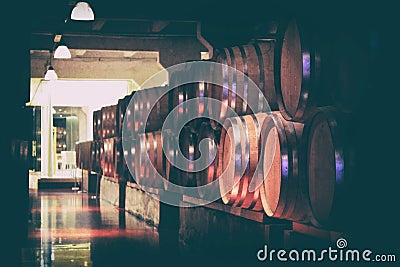 Oak barrels with wine in dark cellar. Modern production of wine with the observance of age-old traditions. Stock Photo