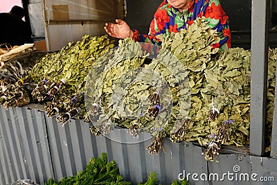 Oak, birch, juniper brooms for a bath. Selling on the market Stock Photo