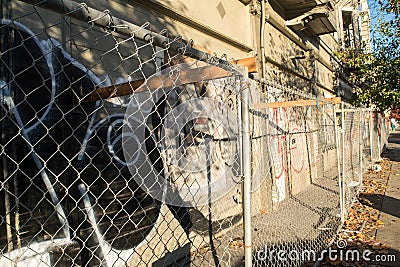 Oakland, abandoned burned out building with graffiti and chain link fence Stock Photo