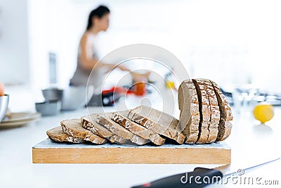 Oat bread and young woman cooking in the background. Stock Photo