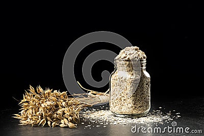 Oat bunch and flakes in flavouring jar Stock Photo