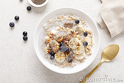 Oatmeal bowl. Oat porridge with banana, blueberry, walnut, chia seeds. Stock Photo