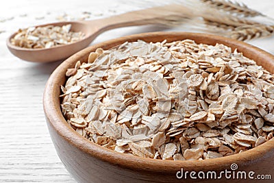 Oatmeal, bowl and spoon on white table, closeup Stock Photo