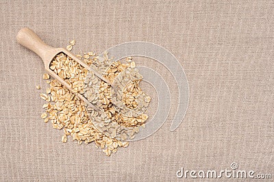 Oatmeal cereal. scoop and pile of oatmeal with its plant. wooden scoop with Dry rolled oatmeal. Oat flakes. top view Stock Photo