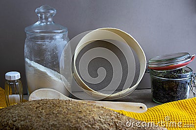 Oatmeal diet bread on a yellow towel in the background is satiated for flour, a jar of flour, spices and a spoon Stock Photo