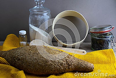 Oatmeal diet bread on a yellow towel in the background is satiated for flour, a jar of flour, spices and a spoon Stock Photo