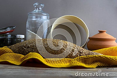 Oatmeal diet bread on a yellow towel in the background is satiated for flour, a jar of flour, spices and a spoon Stock Photo