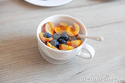 Oatmeal with different berries in bowl on wooden table Stock Photo