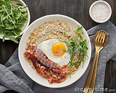 Oatmeal, fried egg and fried bacon. Brutal man sport breakfast. Hearty fat high-calorie breakfast Stock Photo