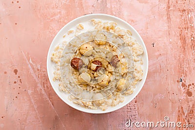 Oatmeal with hazelnut and honey on pink background Stock Photo