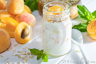 Oatmeal milkshake, smoothie or yogurt with fresh apricot on a white wooden table Stock Photo