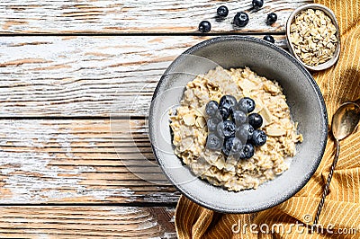 Oatmeal porridge with blueberries and almonds. White wooden background. Top view. Copy space Stock Photo