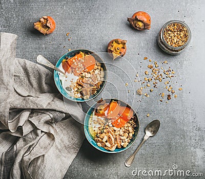 Oatmeal, quinoa granola with yogurt, dried fruit, seeds, honey, persimmon Stock Photo