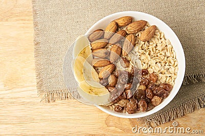 Oatmeal with raisins banana and almonds. White cup Stock Photo