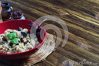 Oatmeal with raisins, branch of wild rose and mint. Stock Photo