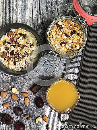 Superfoods smoothies bowls topped with banana, Corn flakes, almond, granola with orange juice. Stock Photo