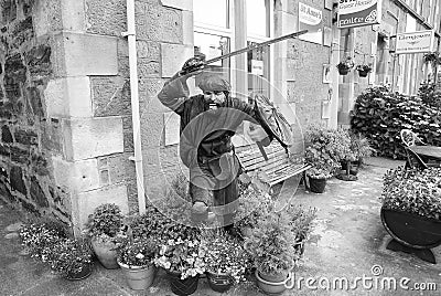 Oban, United Kingdom - February 20, 2010: warrior statue on building corner with pot plants. Town house with bench and Editorial Stock Photo