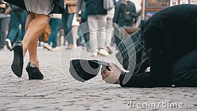 Obdachloser Bettler Man mit einem Hut auf dem Bürgersteig bittet um Almosen von den Leuten, die vorbei überschreiten Langsame Bew stock video footage Obdachloser Bettler Man mit einem Hut auf dem Bürgersteig bittet um Almosen von den Leuten, die vorbei überschreiten Langsame Bew stock video footage
