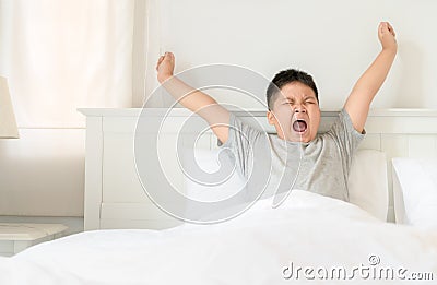 Obese boy wake up yawning and stretch Stock Photo