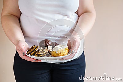 Obese woman eating sweets holding plate of cookies Stock Photo