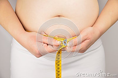 Obese woman measuring his waist with a measuring tape Stock Photo