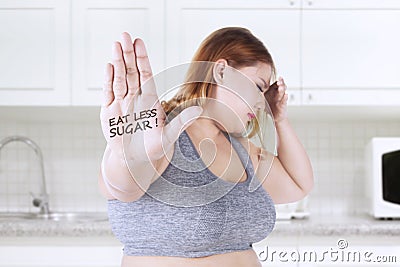 Obese woman shows eat less sugar text Stock Photo