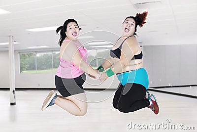 Obese women leaping together in gym Stock Photo