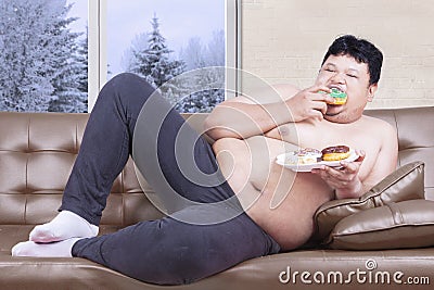 Obesity man eating donuts in winter season Stock Photo