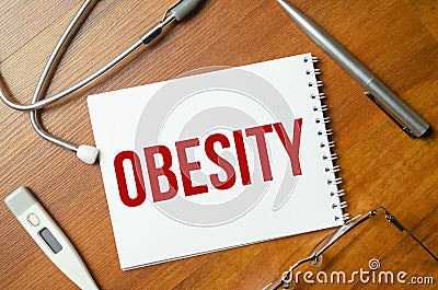 OBESITY text on white paper on the white background. stethoscope Stock Photo