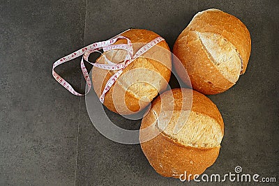 Obesity and whole wheat bread, tape measure wrapped in a large bread Stock Photo